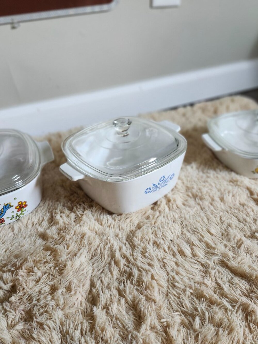 Three CorningWare casserole dishes with lids
